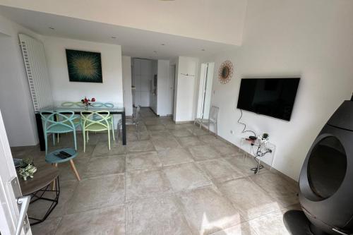 un salon avec une table et une télévision dans l'établissement Pretty harbour house with garden, à Mandelieu-la-Napoule