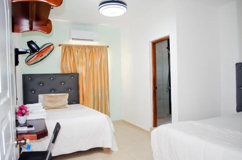 a hotel room with two beds and a window at Hotel las Nina in Paraíso