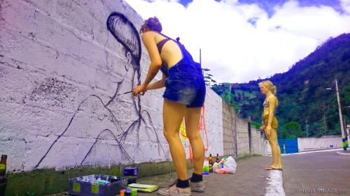 a woman is standing next to a wall at La Casa del Molino Blanco B&B in Baños