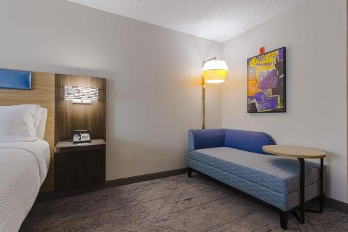 a room with a bed and a chair and a table at Holiday Inn Express Hartford-Newington by IHG in Newington