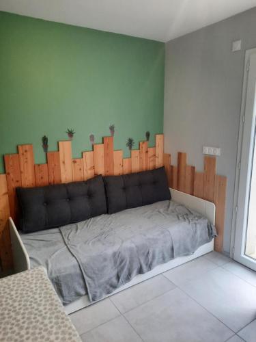 - une chambre avec un lit et une clôture en bois dans l'établissement Studio Saint Montan Ardèche, à Saint-Montan