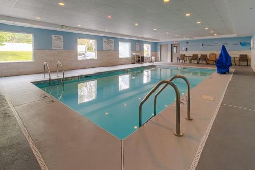 a swimming pool with blue water in a building at Holiday Inn Express Hartford-Newington by IHG in Newington
