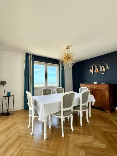 une salle à manger avec une table et des chaises blanches dans l'établissement Rêve bleu, à Royan