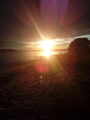 a sunset on the beach with the sun going down at Porto Kalliali in Ouranoupoli