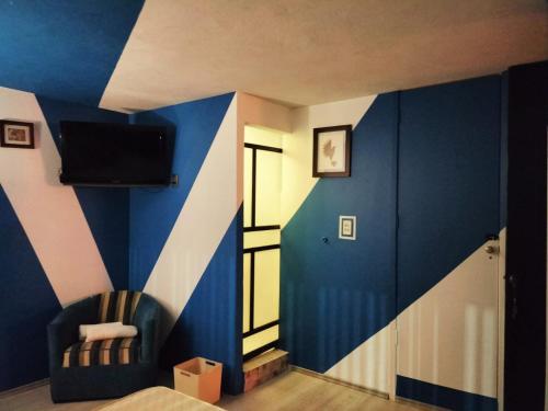 a bedroom with a blue and white stripe wall at Posada Bugambilia in Mexico City