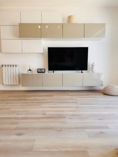 a living room with a flat screen tv on a white wall at Appartamento Felice in Milo