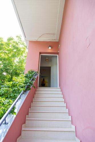 a staircase leading up to a pink building at Aurora Premium Hospitality in Parga