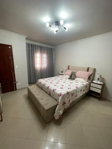 a bedroom with a large bed with a phone on it at PA 432 Linda Casa na Penha Próximo Metro Shopping Facil Acesso Guarulhos e Arena Corinthians in Sao Paulo
