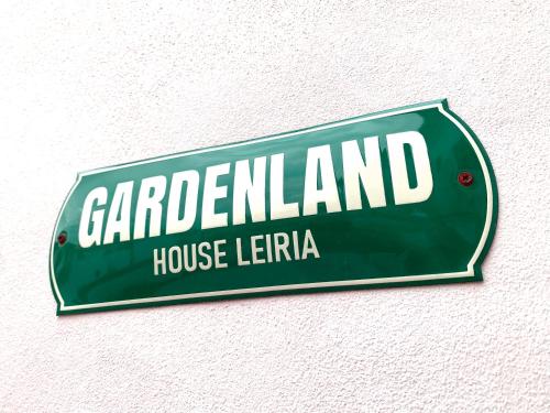 a green street sign on the side of a building at Gardenland House Leiria in Leiria