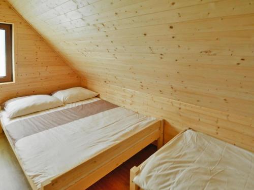 a room with two beds in a log cabin at Cottage in Sarbinowo near Baltic Sea Beach in Sarbinowo