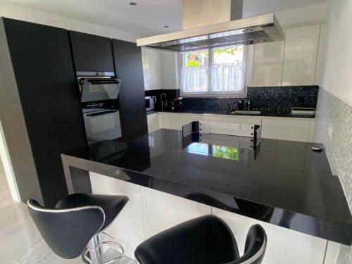 a black and white kitchen with black counter tops at Cozy Escape House - 12 min to Zurich HB - Free Parking in Ober Urdorf