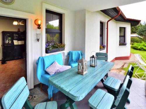 a patio with a blue table and chairs at Villa in Kr g near Knight's Castle in Pollnow