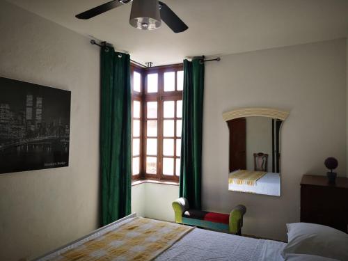 a bedroom with a bed and a window with green curtains at Apartamento en Playa de Morro jable 1 habitación in Morro del Jable