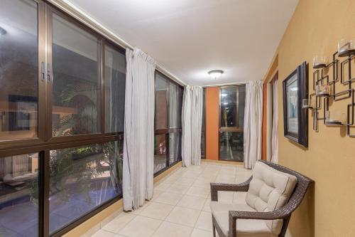 a living room with two chairs and large windows at Green Villas El Coco in Coco