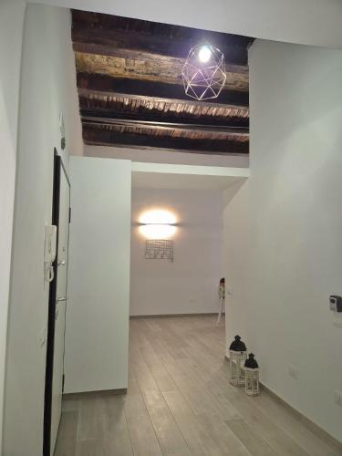 een lege kamer met een plafond met een kroonluchter bij La Memolina B&B in Salerno