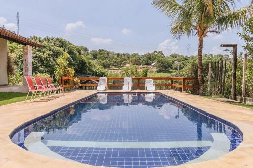 a swimming pool in a yard with chairs and a house at Casa Linda Vista in Itupeva