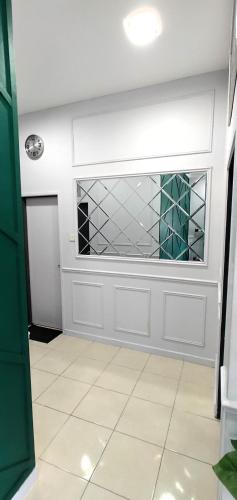 a bathroom with a window and a white tile floor at CozyRizqy Homestay at Kebun Baru - 3R2B in Jenjarum