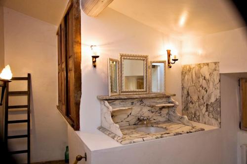 une salle de bain avec un lavabo en pierre et un miroir dans l'établissement La maison Renaissance, à Grambois