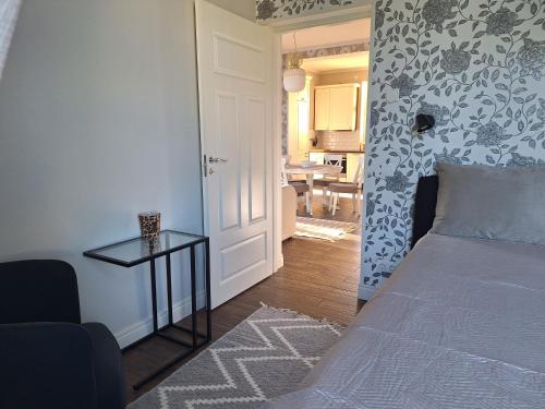 a bedroom with a bed and a table next to a door at Villa Marienholm in Haapsalu