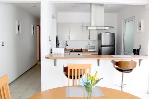 a kitchen with white cabinets and a table and chairs at Departamento Zona Las Américas in Morelia