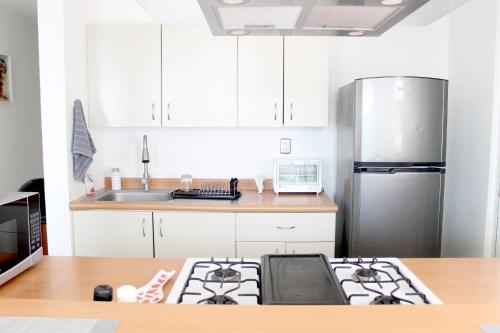 a kitchen with a stove and a stainless steel refrigerator at Departamento Zona Las Américas in Morelia