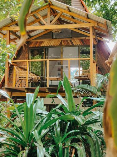 a house in the forest with chairs and plants at Calala Lodge in Cabuya