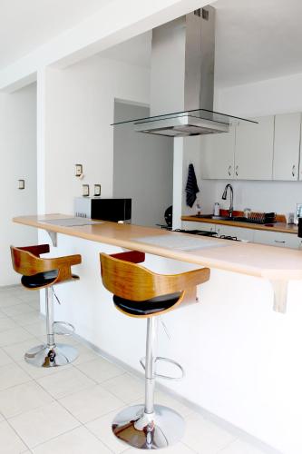 a kitchen with a counter and two bar stools at Departamento Zona Las Américas in Morelia