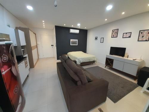 a living room with a couch and a bed at JK STUDIO PREMIUM COM GARAGEM SEM taxas extras in Pelotas