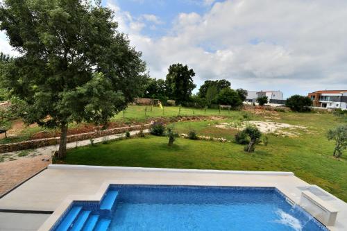 ein Swimmingpool mit Blick auf eine Wiese in der Unterkunft Villa Vala in Marčana