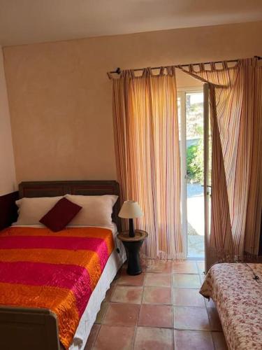 une chambre avec un lit et une porte coulissante en verre dans l'établissement Grand Mas avec piscine sur Ramatuelle-Saint-Tropez, à Ramatuelle