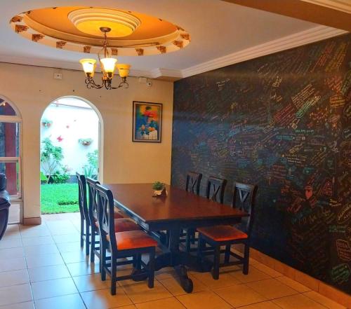 a dining room with a table with chairs and a chalkboard at Hotel Don Felipe Aeropuerto in Guatemala