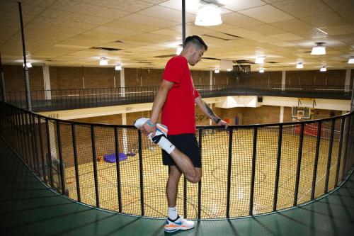 a man is standing in a batting cage at Spokane Club Hotel in Spokane