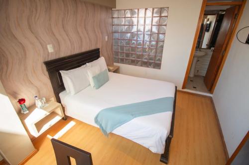 a bedroom with a white bed and a window at Inti Tampu Inn in Cusco