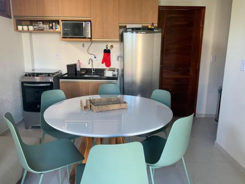 a kitchen with a table and chairs and a refrigerator at Casa 3 Atins in Atins