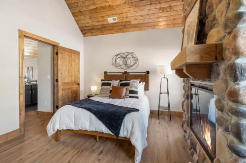 a bedroom with a bed and a stone fireplace at Private Hot Tub-Free Attraction Tickets-Lake Lookout-Community Indoor & Outdoor Pools in Branson