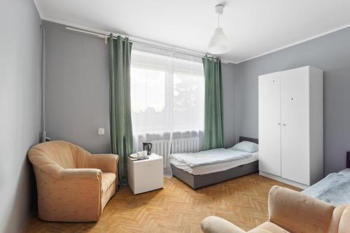a bedroom with a bed and a chair and a window at Tanie Spanie Autostrada A2 in Poznań