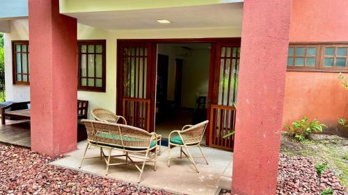 a group of chairs sitting on the front porch of a house at Apartamento Reserva Time Antube Praia do Forte in Mata de Sao Joao