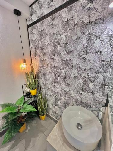 a bathroom with a toilet and a flower wall at Hotel Citadin Z10 in Guatemala