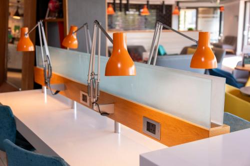 a row of desks with orange lights on them at Holiday Inn London Brentford Lock by IHG in Brentford