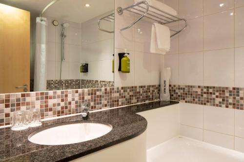 a bathroom with a sink and a mirror at Holiday Inn London Brentford Lock by IHG in Brentford