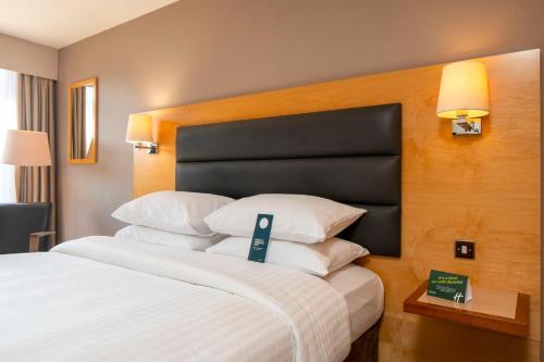 a hotel room with a large bed with white pillows at Holiday Inn London Brentford Lock by IHG in Brentford