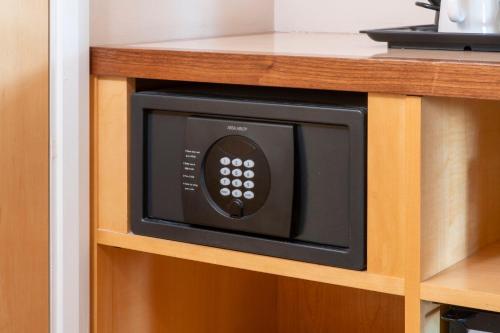 a microwave oven in a cabinet in a kitchen at Holiday Inn London Brentford Lock by IHG in Brentford