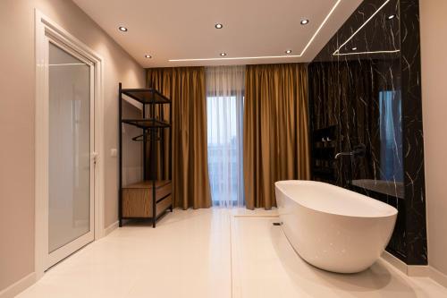 a bathroom with a large white bath tub in a room at Diol Hotel Ksamil in Ksamil