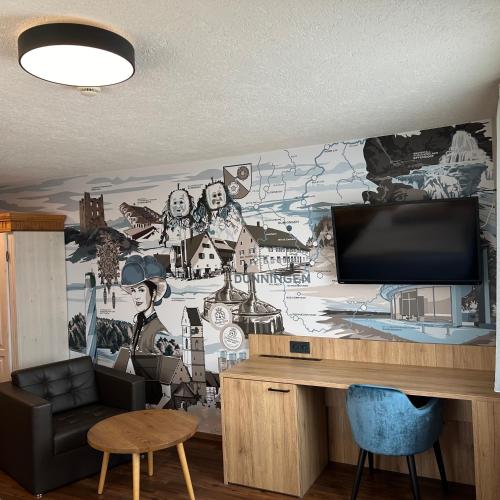 a living room with a tv and a wall mural at Braustube Wehle in Dunningen
