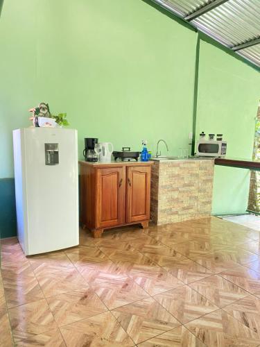 a kitchen with a white refrigerator and wooden cabinets at Campo Verde House, La Fortuna de San Carlos in Fortuna