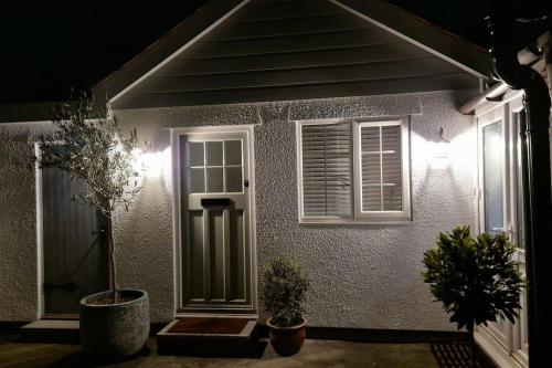 a house with two potted plants in front of it at The Little Baytree in Worle