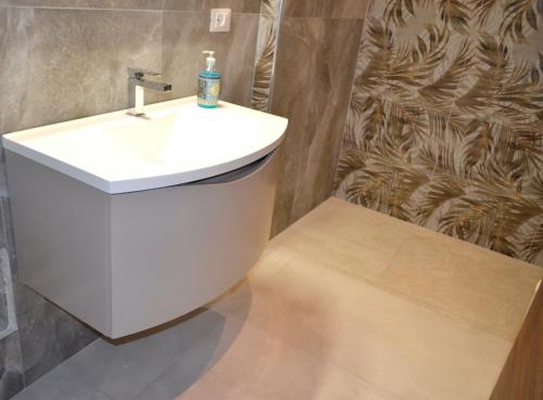 a bathroom with a white sink and a wall at Monolocale Casa Palma in Nardò