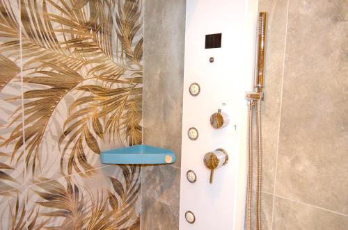 a bathroom with a white door with a tropical wallpaper at Monolocale Casa Palma in Nardò