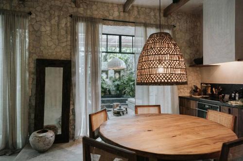 图卢姆Design Loft with private pool and SPA like feature的厨房配有木桌和大窗户。