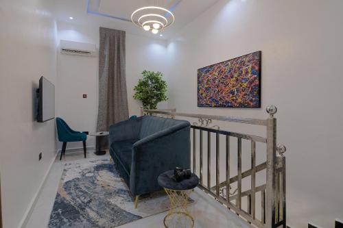 a living room with a blue couch and a chair at One90 Apartment in Lagos